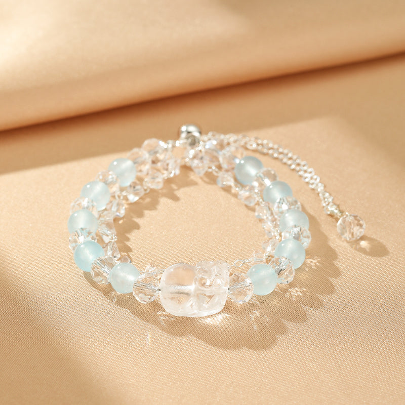 Bracelet double rang de perles d'aigue-marine et de cristal de roche avec une breloque centrale en cristal de roche sculpté. Fermoir argenté.