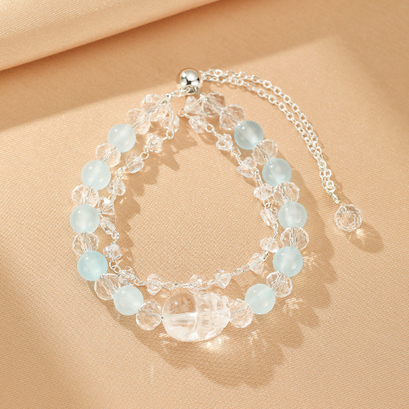 Bracelet double rangs en aigue-marine naturelle et cristal de roche, avec fermoir en argent et une perle centrale facettée.