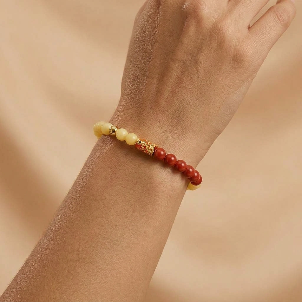 Bracelet Carpe Joyeuse composé de perles d'ambre jaune et de cinabre rouge portées au poignet