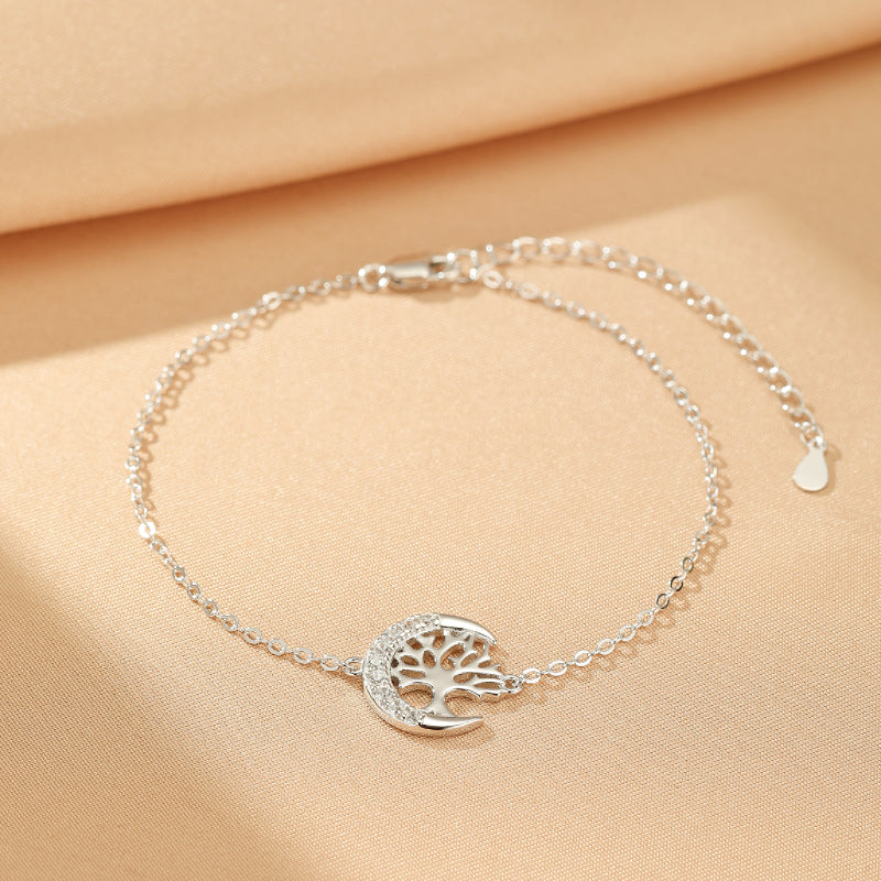 Bracelet Arbre de Vie en argent avec un motif d'arbre stylisé incrusté dans un croissant de lune orné de petites pierres.