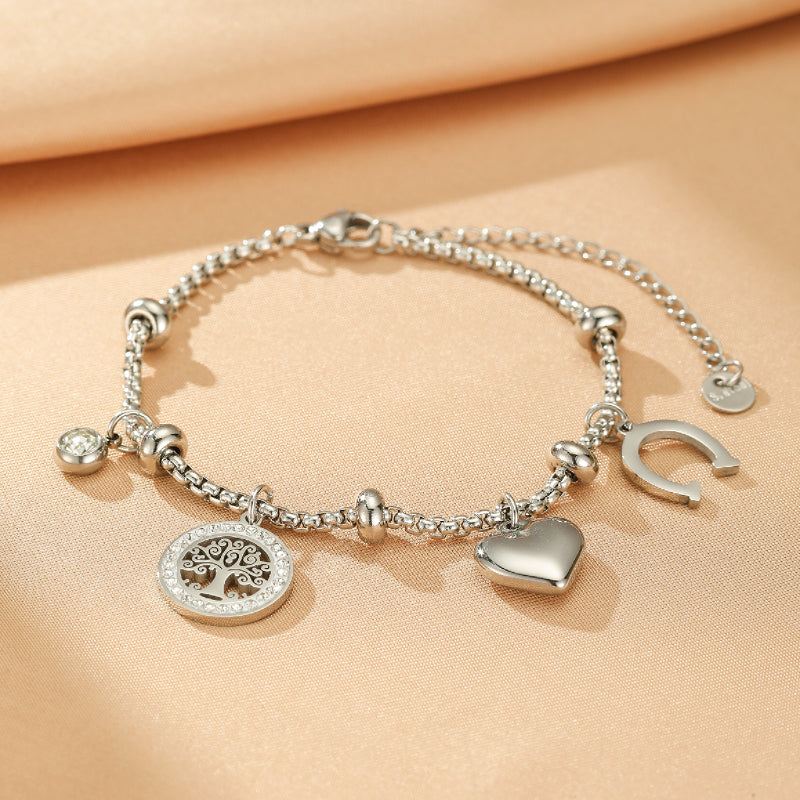 Bracelet en argent "Arbre de Vie" avec des breloques en forme de cœur, de fer à cheval et de rond avec un arbre de vie orné de strass.