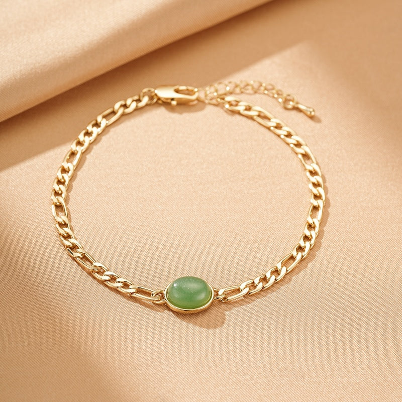 Bracelet en plaqué or avec une pierre d'aventurine verte ovale au centre, maillons de type figaro, fermoir mousqueton.