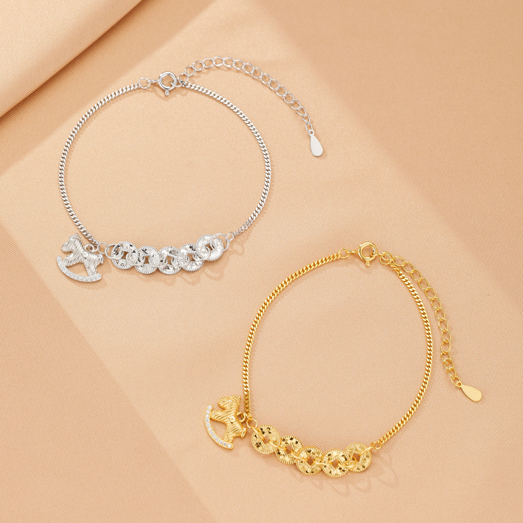 Bracelet en argent avec un charm de cheval à bascule et cinq pièces rondes, disponible aussi en doré.