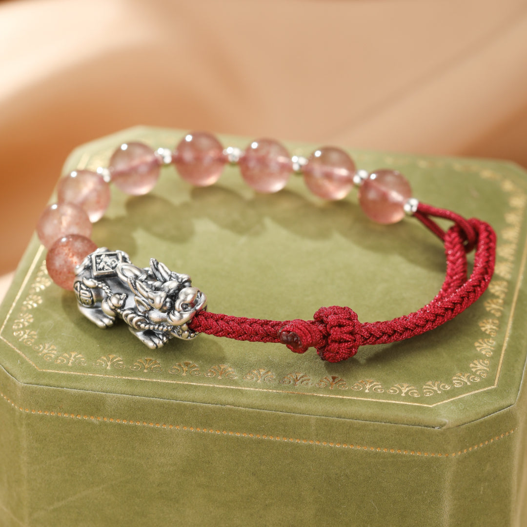 Bracelet Pi Xiu en argent orné de perles roses et d'un fil rouge, symbole d'union sacrée.