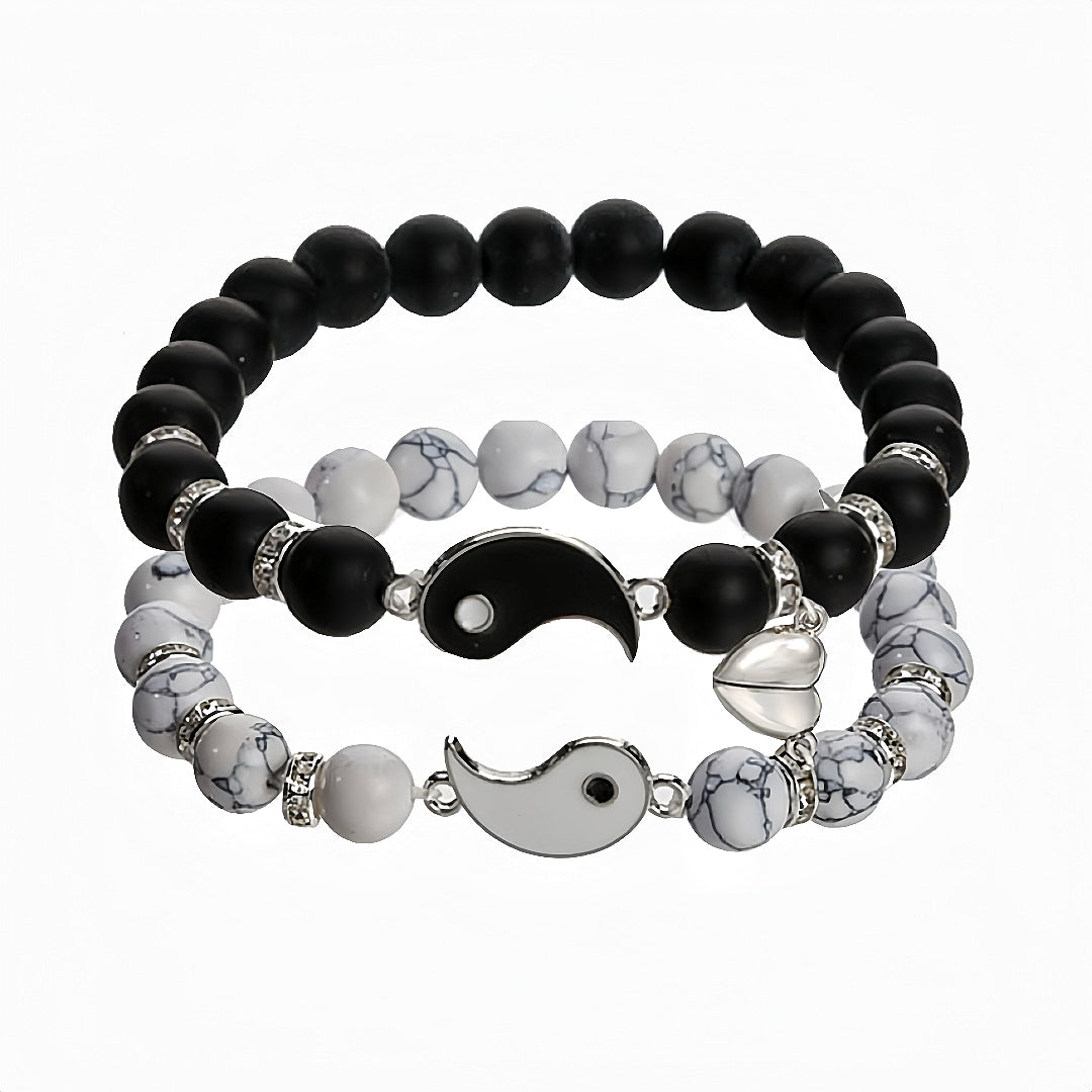 Deux bracelets assortis pour couple, un avec des perles noires de lave et l'autre avec des perles blanches de howlite, ornés de pendentifs Yin et Yang.