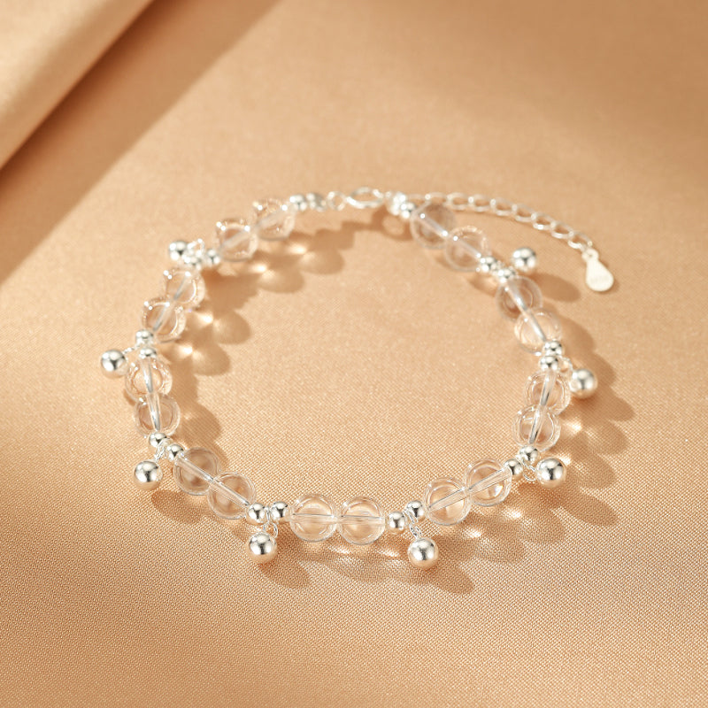 Bracelet "Éclat de Pureté" en cristal de roche et argent, orné de perles argentées suspendues.