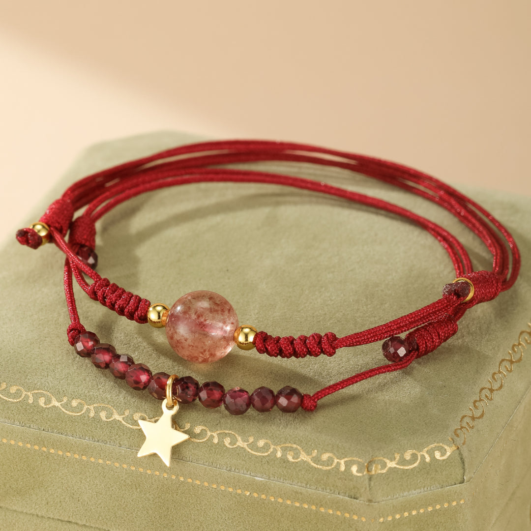 Ensemble de deux bracelets rouges : un avec une perle ronde de quartz fraise et des perles dorées, l'autre avec des petites perles grenat et un pendentif étoile doré.