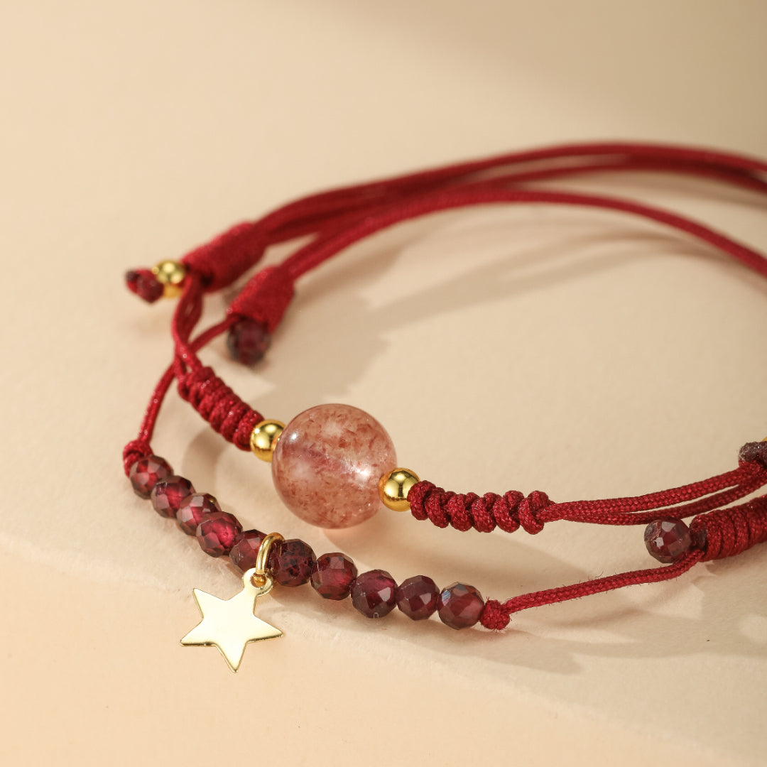 Bracelet double rang avec perles de grenat, une grosse perle de quartz fraise et un pendentif étoile doré, monté sur cordon rouge.