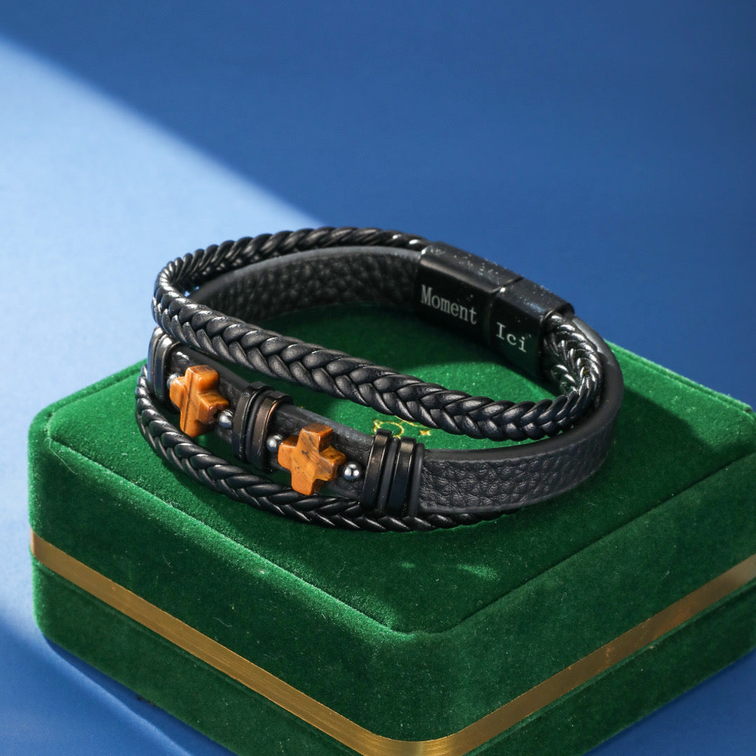 Bracelet homme double rang en cuir noir tressé et lisse, orné de perles œil de tigre en forme de croix et de perles argentées, fermoir noir.