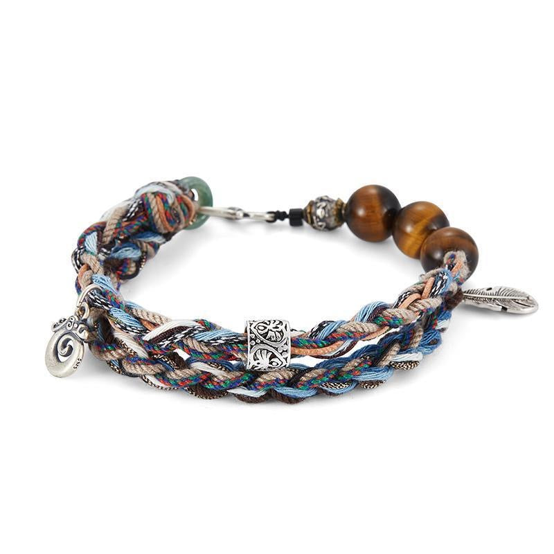 Bracelet tressé multicolore avec perles œil de tigre, breloque plume et fermoir argenté, style aventurier.