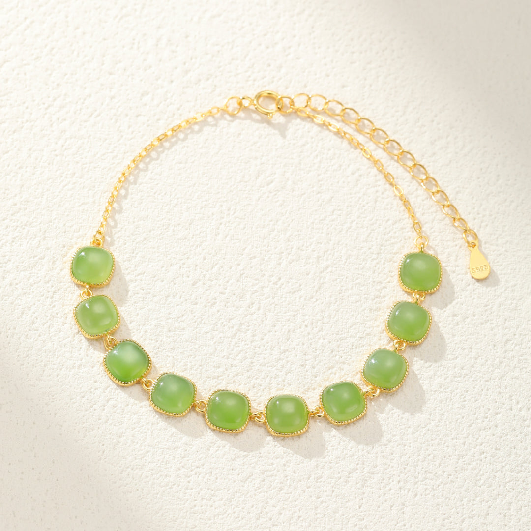 Bracelet en jade avec des perles carrées vert clair montées sur une chaîne en argent plaqué or, fermoir mousqueton et chaîne de rallonge.