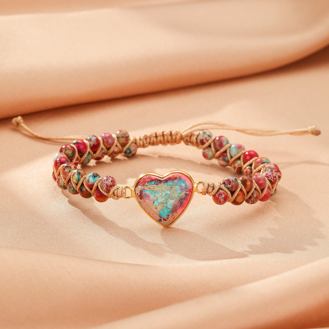 Bracelet en jaspe avec un pendentif en forme de cœur coloré, monté sur un cordon tressé beige.