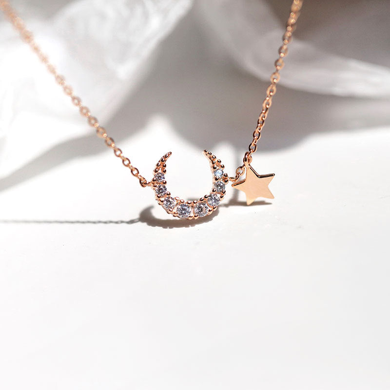 Collier délicat en argent avec un pendentif croissant de lune orné de zirconiums et une petite étoile, chaîne fine.