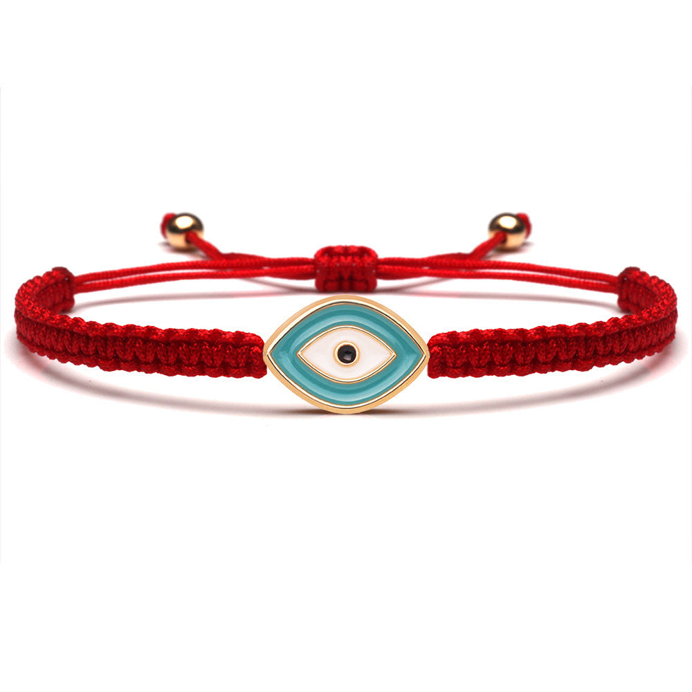 Bracelet œil bleu "Force Spirituelle" avec fil rouge tressé et fermoirs dorés, symbole de protection.