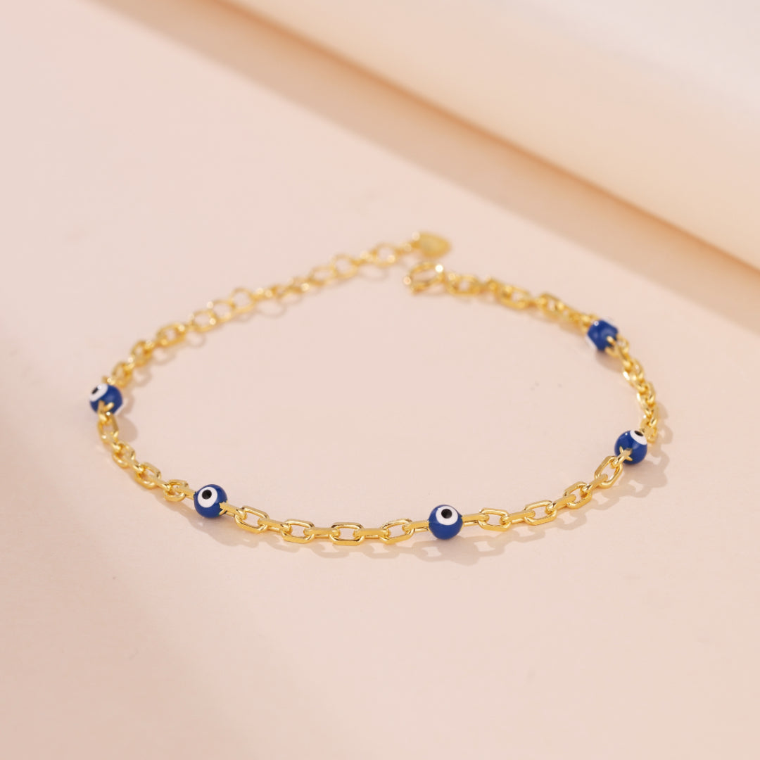 Bracelet chaîne en argent 925 plaqué or avec des perles bleues œil du mal et une breloque étoile.