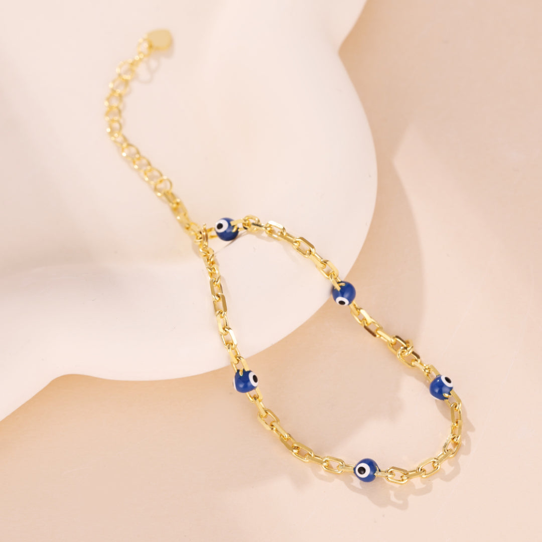 Bracelet en argent 925 avec un maillon de chaîne dorée et plusieurs breloques œil bleu protecteur