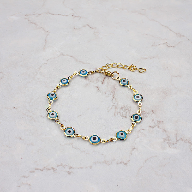 Bracelet Luna Guard avec des breloques œil bleu et doré sur fond marbre