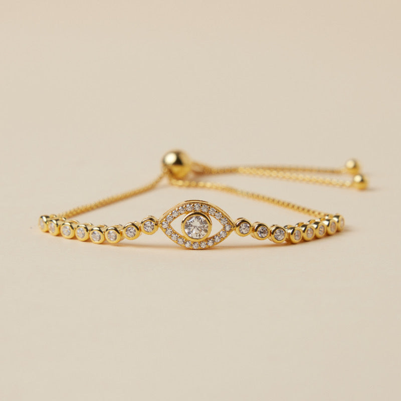 Bracelet délicat en argent plaqué or, orné d'un motif œil du destin stylisé et serti de cristaux scintillants, avec une chaîne ajustable.