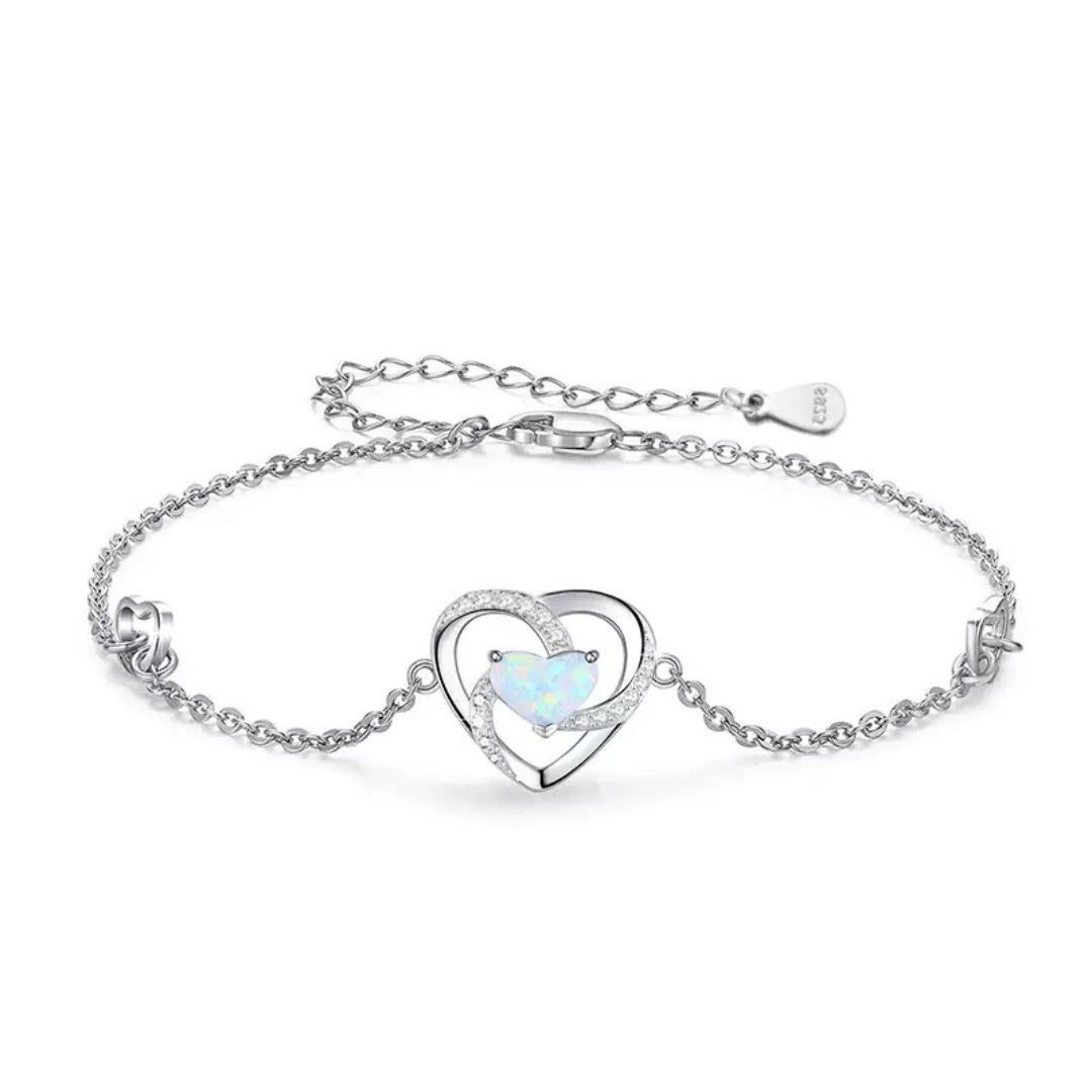 Bracelet en argent orné d'un pendentif cœur double, incrusté d'une opale centrale et de cristaux scintillants, chaîne délicate.