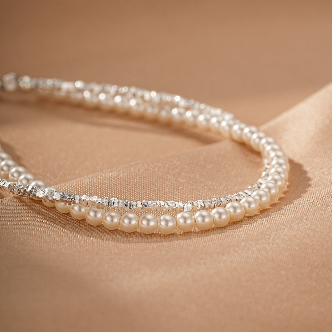 Bracelet double rangs en argent et perles nacrées, fini brillant sur fond satiné beige