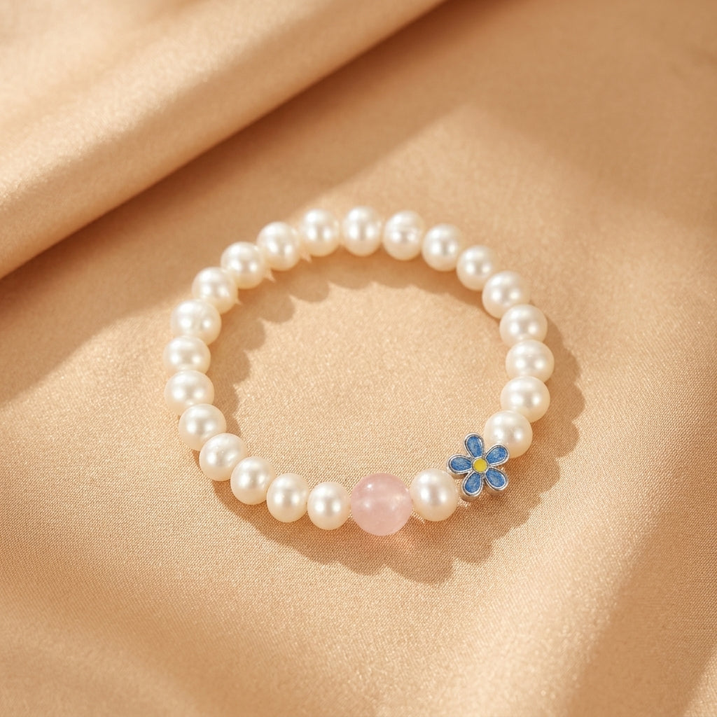 Bracelet en argent pur avec perles blanches, une perle centrale en quartz rose et un charmant pendentif fleur bleu et jaune.