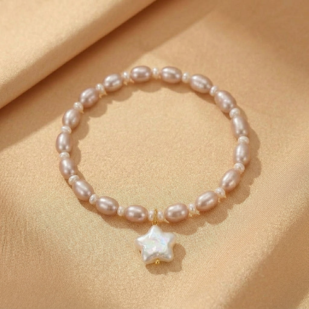 Bracelet Perle – Souffle Infini, fait de perles roses pâles et d'un pendentif étoile nacré.