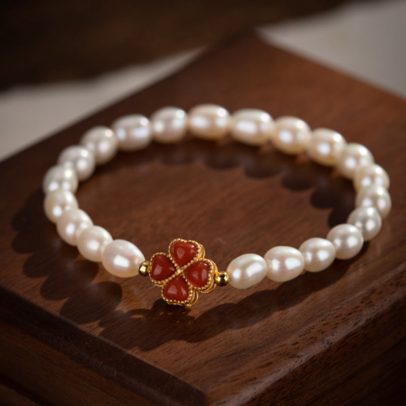 Bracelet en perles d'eau douce avec un charmant trèfle en argent plaqué or et pierre rouge
