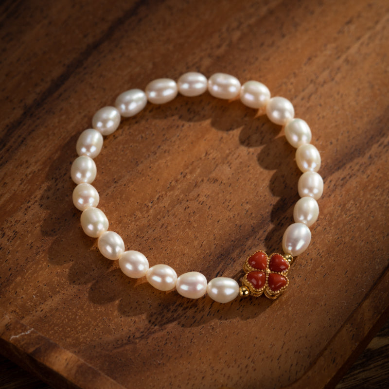 Bracelet en perles d'eau douce avec un fermoir en forme de trèfle à quatre feuilles en corail rouge et plaqué or.