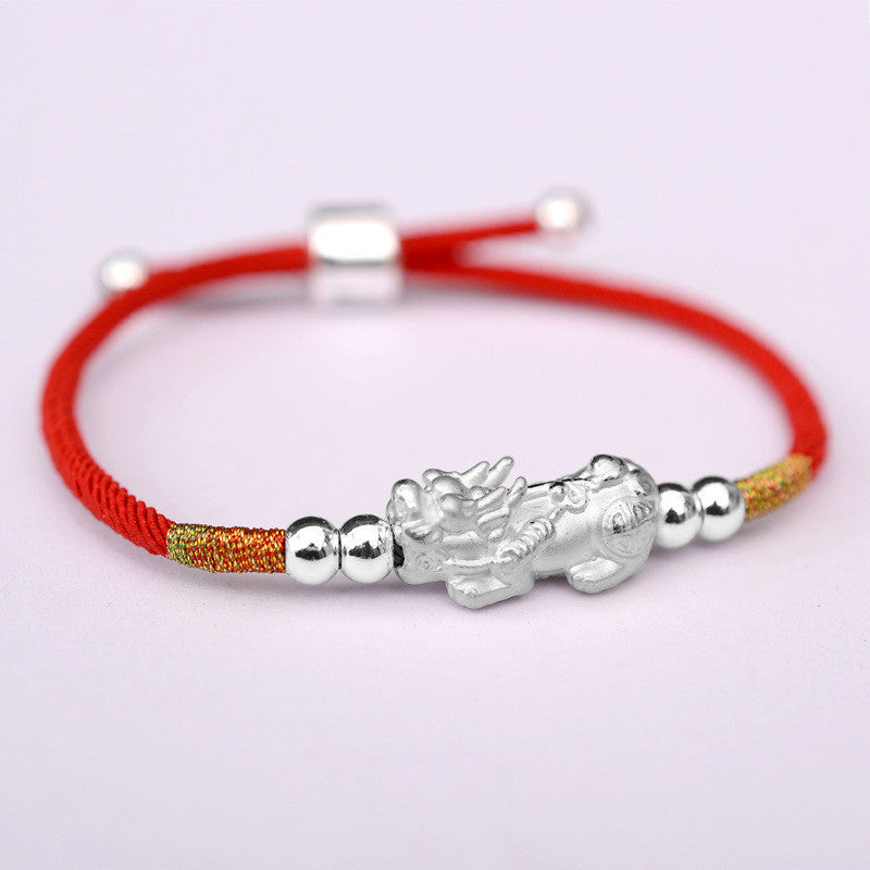Bracelet Pi Xiu mythique en fil rouge avec des perles argentées et une figurine de créature mythologique Pi Xiu argentée.