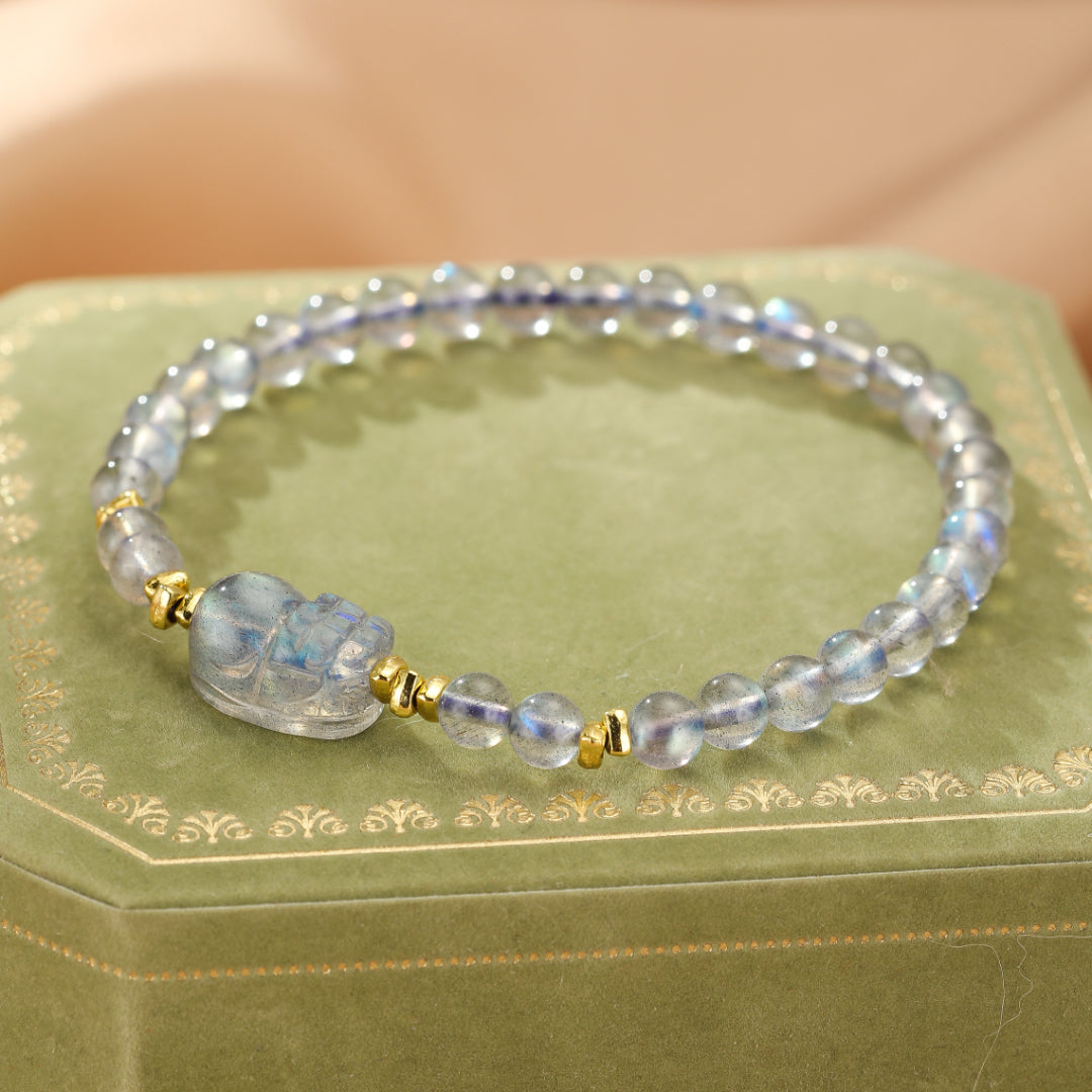 Bracelet en argent plaqué or avec perles de labradorite et une figurine Pi Xiu transparente, création "Magie Nocturne".