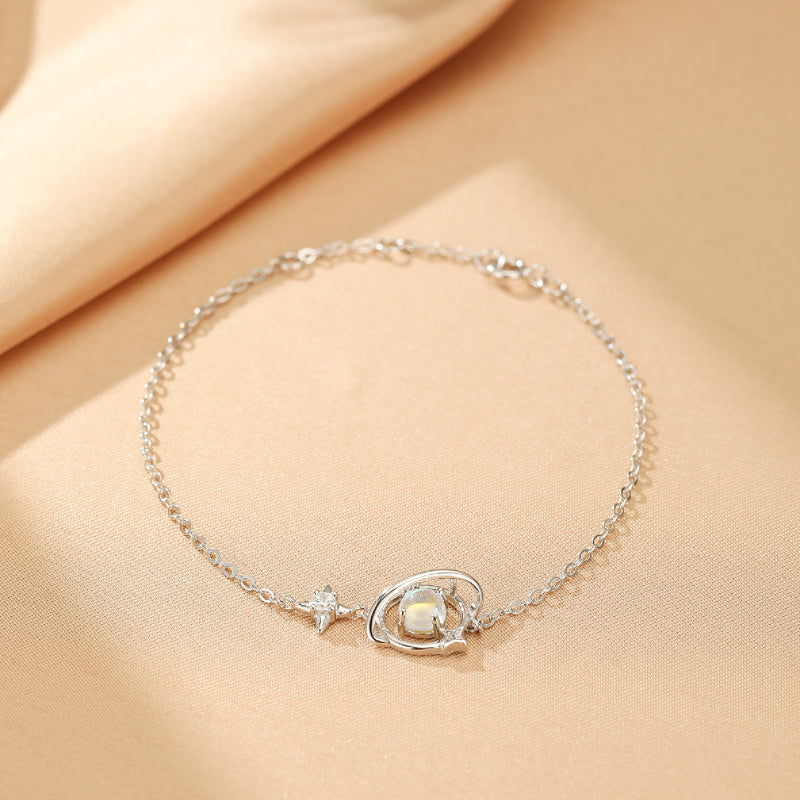 Bracelet en argent 925 avec une pierre de lune opalescente et une étoile scintillante, style galactique.