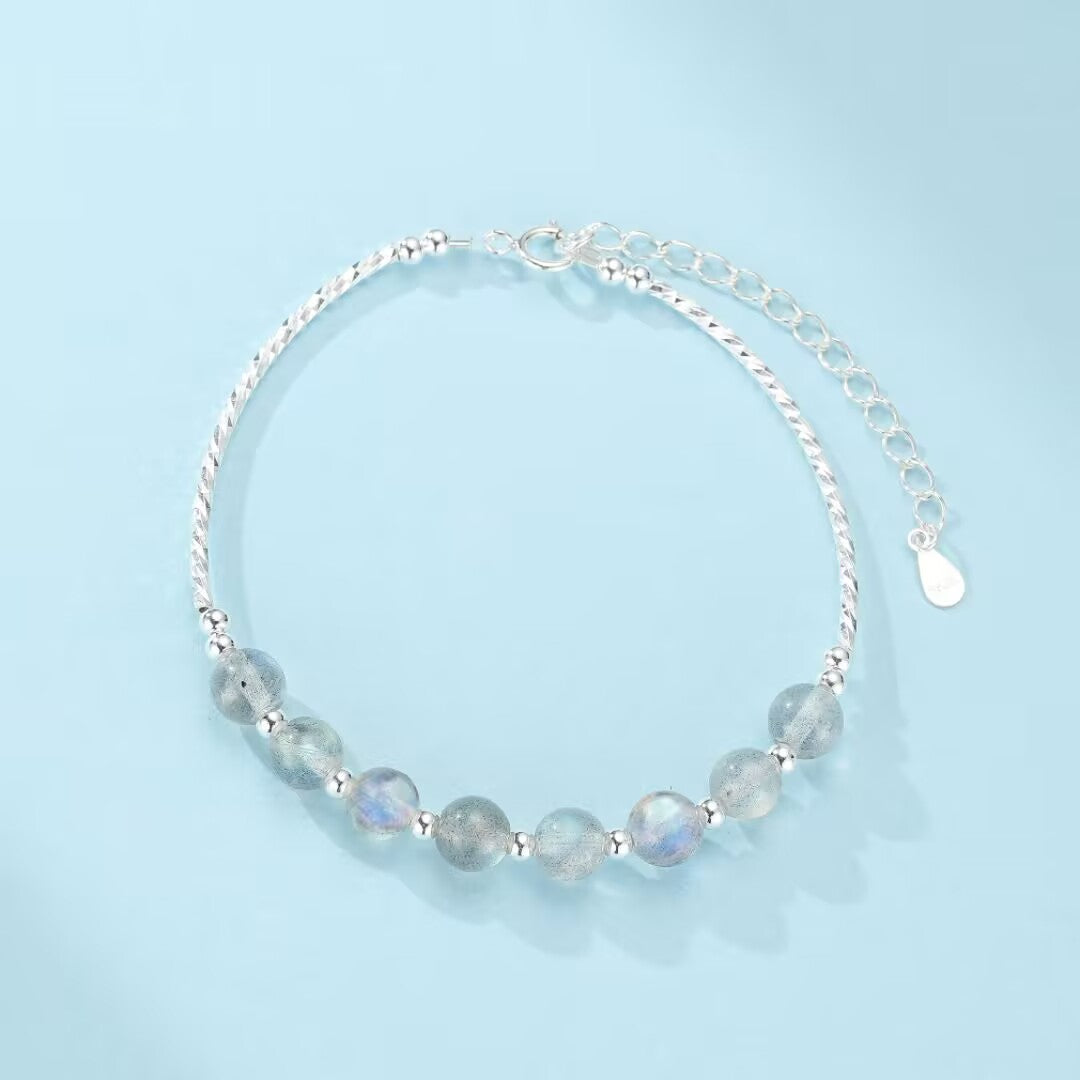 Bracelet en argent 925 avec des perles de pierre de lune bleutées et une chaîne torsadée réglable.