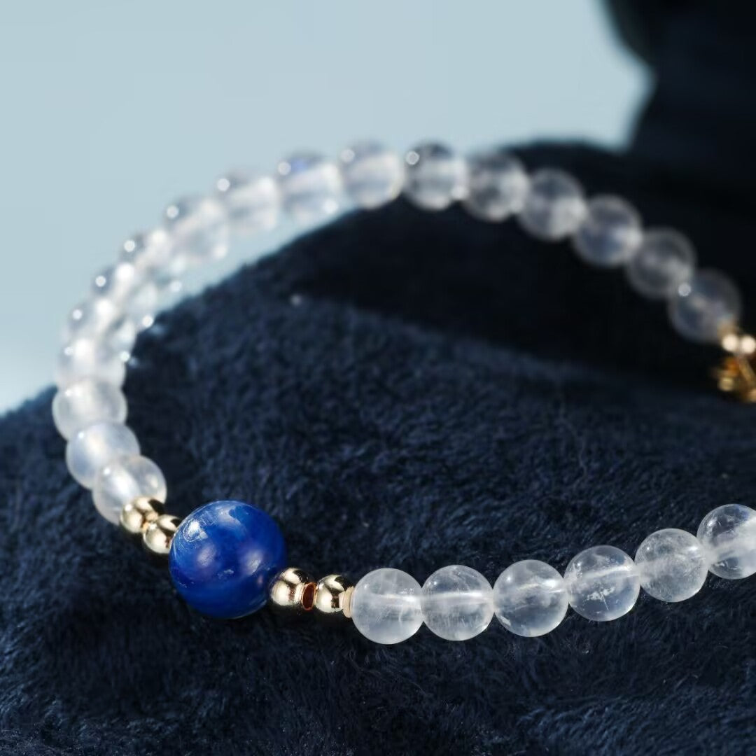 Bracelet Voyage Stellaire en pierres de lune translucides et une perle centrale bleue lapis-lazuli, rehaussé de petites perles dorées.