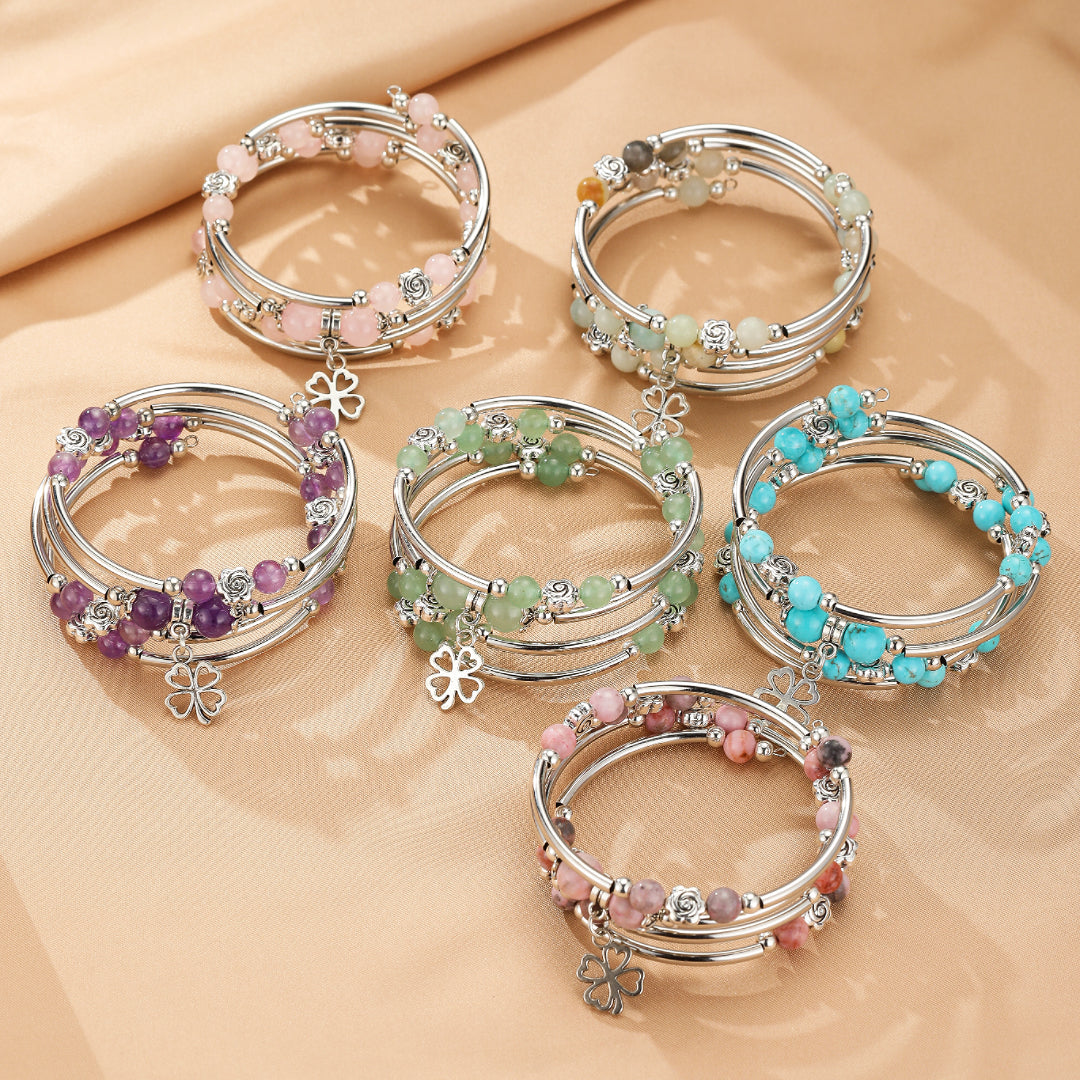 Ensemble de bracelets jonc en pierres naturelles multicolores (rose, violet, vert, turquoise) avec breloques trèfle à quatre feuilles.