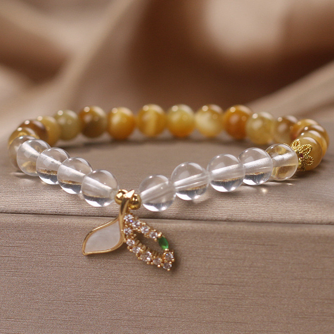 Bracelet fait main avec des perles de quartz clair et d'œil de tigre, orné d'un pendentif en forme de queue de sirène serti de zirconiums et d'une petite pierre verte.