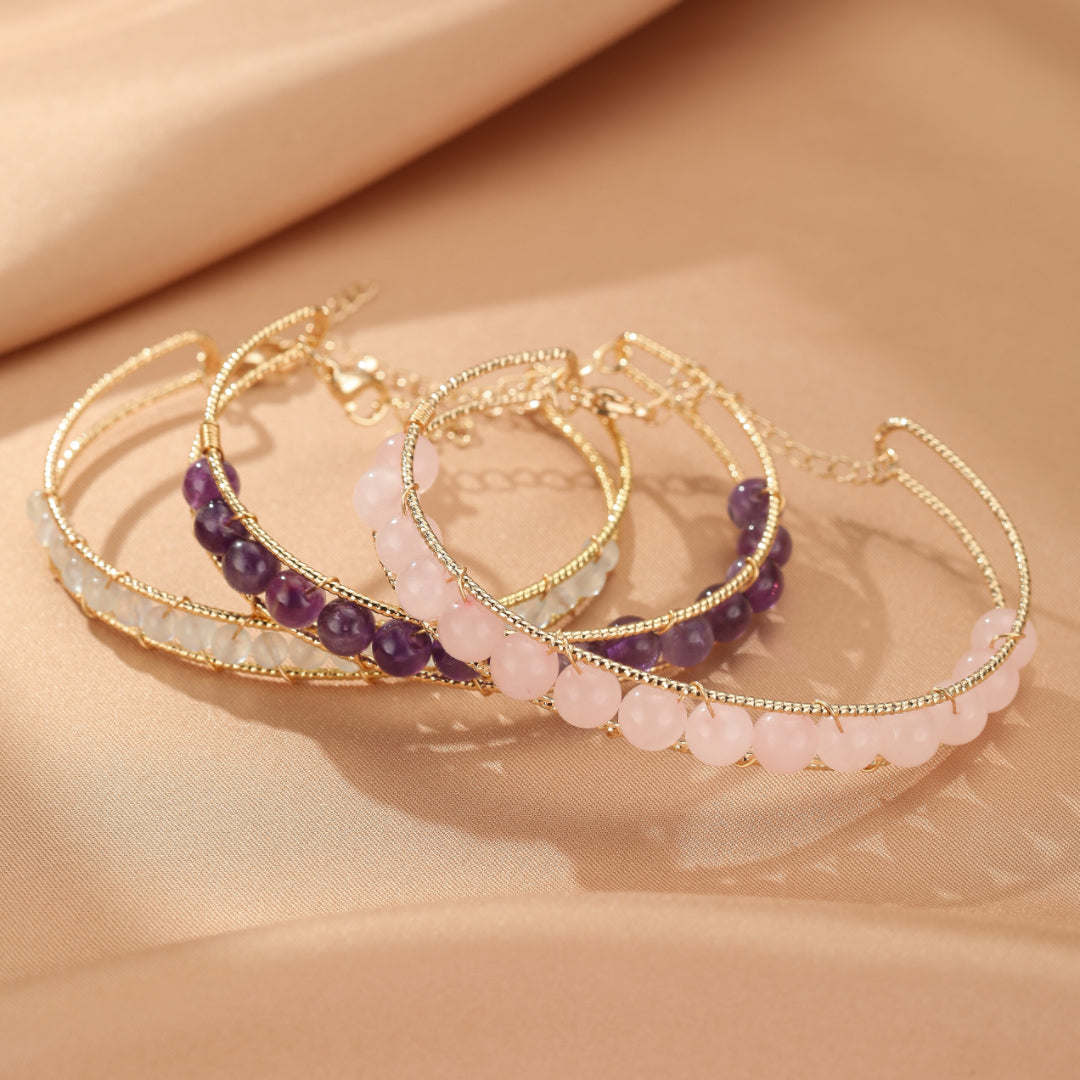 Trois bracelets minimalistes en pierre naturelle : quartz rose, améthyste et aigue-marine, montés sur une armature dorée ajustable.