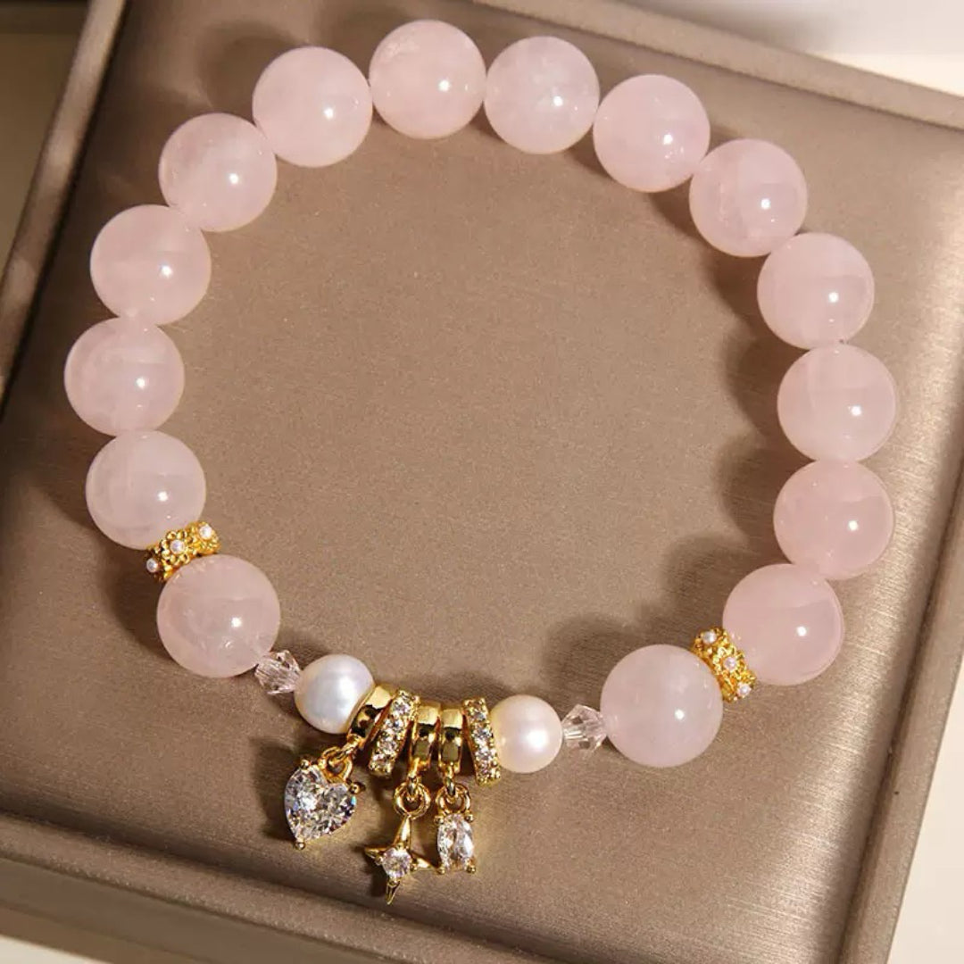 Bracelet élastique en quartz rose avec perles d'eau douce et breloques en forme de cœur et d'étoile incrustées de zircons cubiques, accents dorés et cristaux.