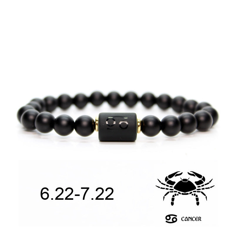 Bracelet en onyx noir avec un signe astrologique du Cancer gravé sur une perle centrale noire, et un symbole du Cancer et "6.22-7.22" en dessous.