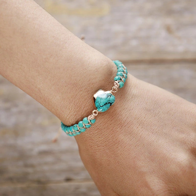 Bracelet Fil d'Amour en argent plaqué or avec une pierre turquoise en forme de cœur au centre et de petites perles turquoise sur le fil.