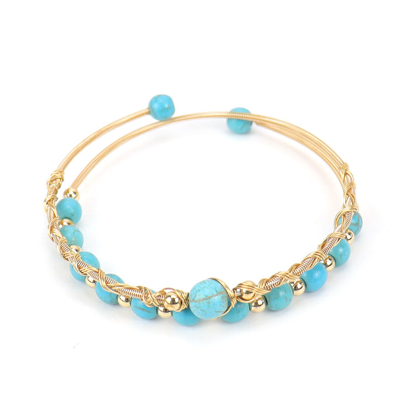 Bracelet jonc en fil d'or torsadé orné de perles turquoise et de petites perles dorées, style bohème chic.