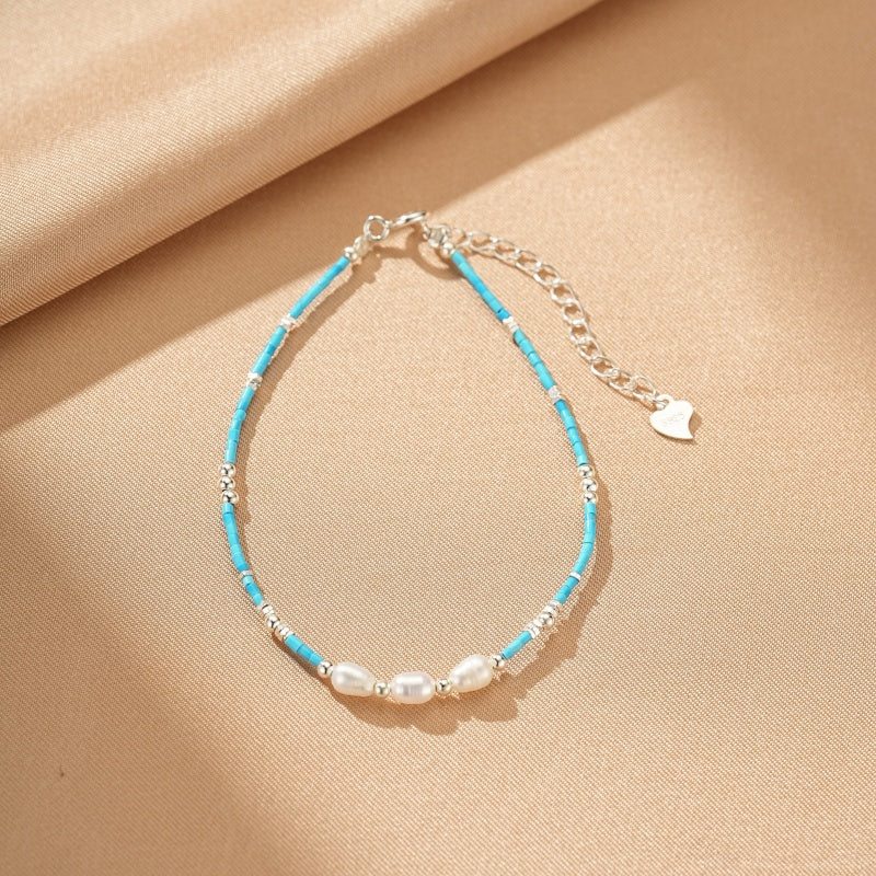 Bracelet "Talisman du Vent" en argent avec perles d'eau douce et turquoise, orné d'un petit pendentif en forme de cœur.