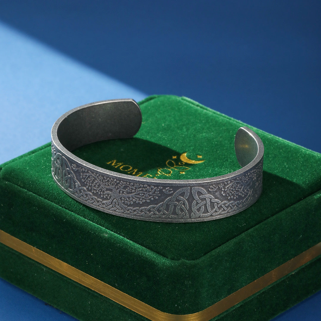 Bracelet Viking Arbre de Vie en métal argenté avec des motifs complexes d'arbres et de nœuds celtiques, sur un écrin vert.