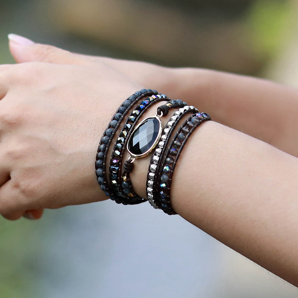 Bracelet jonc "Force" en onyx avec pierres sombres et détails brillants, porté au poignet d'une femme.