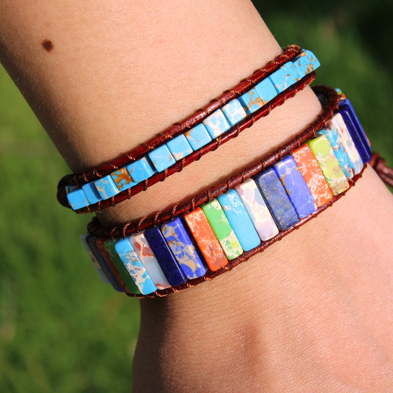 Bracelet Wrap Harmonie en Pierres de 7 Chakras avec des pierres bleues, vertes, oranges et blanches sur un bracelet en cuir marron.