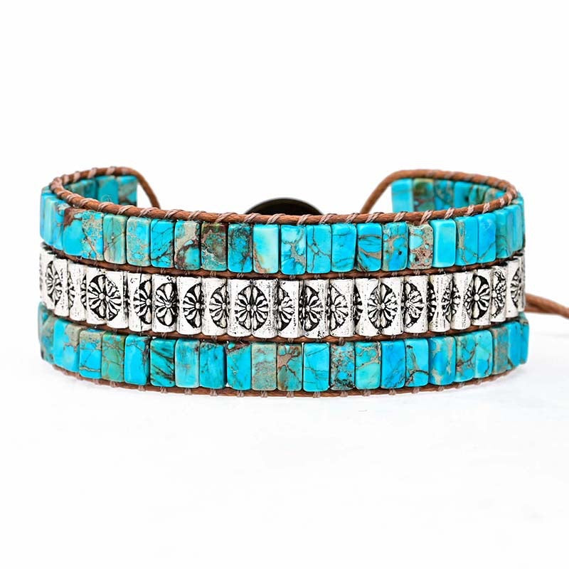 Bracelet manchette ethnique avec pierres turquoise et perles argentées gravées, monté sur cuir marron.