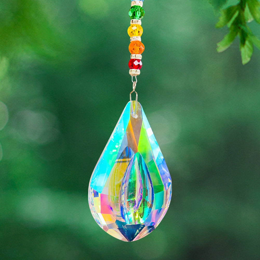 Capteur de soleil goutte d'eau en cristal faceté multicolore avec des perles colorées suspendu à une branche d'arbre
