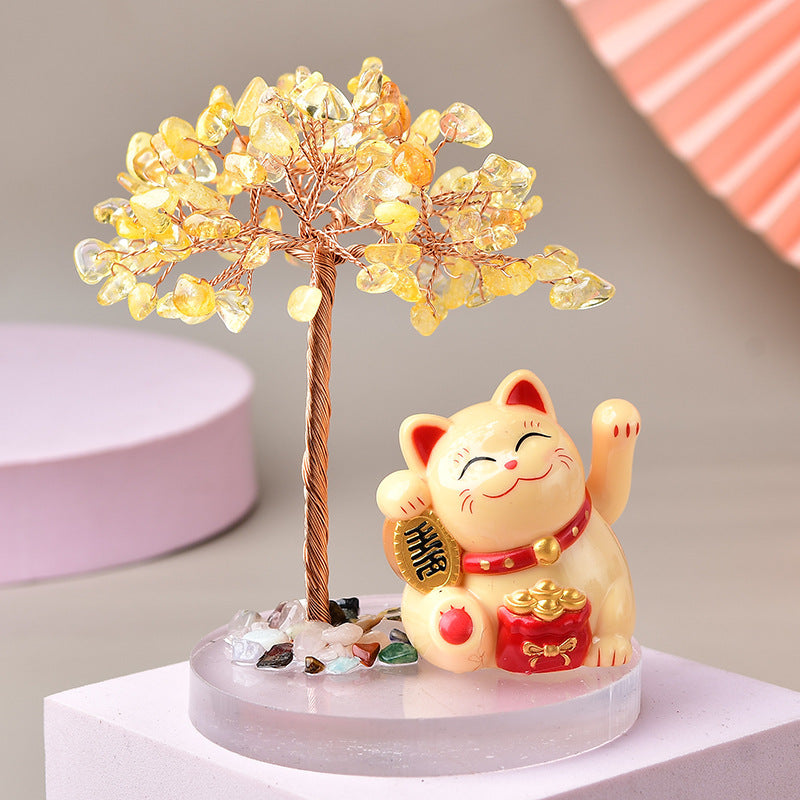 Arbre de vie en pierres naturelles jaunes et un chat Maneki-neko porte-bonheur avec une pièce dorée et un sac d'or, le tout sur un socle transparent.
