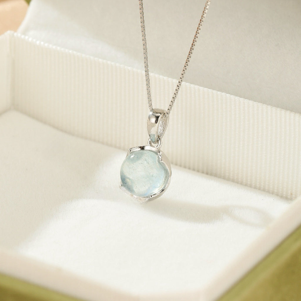 Collier pendentif en argent 925 avec une aigue-marine bleue pâle ronde et une chaîne fine.