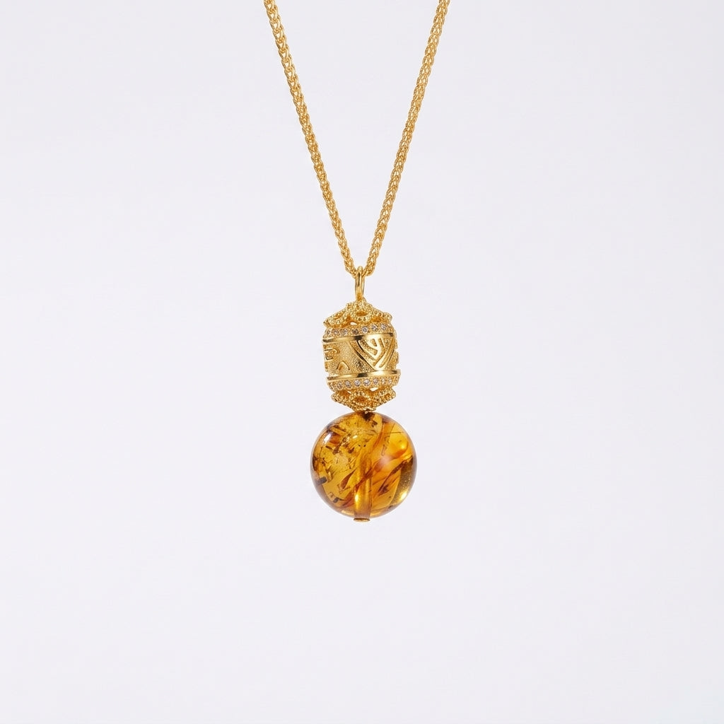 Collier Lueur d’Ambre avec pendentif en ambre naturel et détail travaillé en argent plaqué or, suspendu à une fine chaîne dorée.