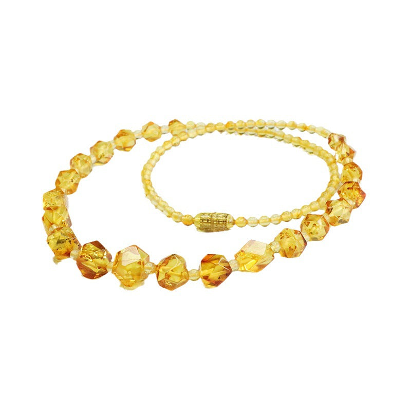 Collier en ambre véritable Sève Éternelle avec perles facettées couleur miel doré, bijou naturel élégant sur fond blanc.